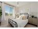 Cozy bedroom with a wrought iron bed, neutral tones, and a window offering a view at 10316 Apefly St, Las Vegas, NV 89141