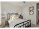 Cozy bedroom with a wrought iron bed, neutral tones, and sliding door closet at 10316 Apefly St, Las Vegas, NV 89141