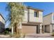 Two-story stucco home with a brown garage door and stone accents and manicured landscaping at 10316 Apefly St, Las Vegas, NV 89141