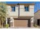 Two-story stucco home with a brown garage door and stone accents with manicured landscaping at 10316 Apefly St, Las Vegas, NV 89141