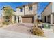 Two-story stucco home with a brick-paved driveway, a brown garage door, and landscaping at 10316 Apefly St, Las Vegas, NV 89141