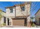Two-story stucco home with a brown garage door and stone accents and manicured landscaping at 10316 Apefly St, Las Vegas, NV 89141