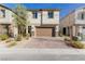 Two-story stucco home with a brown garage door, paved drive, and low-maintenance landscaping at 10316 Apefly St, Las Vegas, NV 89141