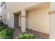 Covered front entryway with a gray door, brick-paved walk, and lush landscaping at 10316 Apefly St, Las Vegas, NV 89141