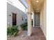 Covered front entryway with a gray door, brick-paved walk, and low-maintenance landscaping at 10316 Apefly St, Las Vegas, NV 89141