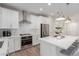 Modern kitchen featuring stainless steel appliances, white cabinetry and island with seating and sleek pendant lighting at 10316 Apefly St, Las Vegas, NV 89141