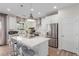 Modern kitchen features stainless steel appliances, white cabinetry, an island with seating and sleek pendant lighting at 10316 Apefly St, Las Vegas, NV 89141