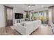 Open-concept living room with stylish sectional sofa, tile floors, media center, and curtains at 10316 Apefly St, Las Vegas, NV 89141