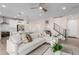 Open concept living area with modern white sectional sofa, kitchen with stainless appliances, and stylish decor at 10316 Apefly St, Las Vegas, NV 89141