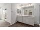 Bright bathroom with double vanity, wood-look floors, large mirror and sliding glass door to the balcony at 10328 Apefly St, Las Vegas, NV 89141
