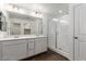 Primary bathroom featuring double sinks, quartz counters, and walk-in shower at 10328 Apefly St, Las Vegas, NV 89141