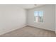 Bedroom features neutral carpet and view of a neighboring home at 10328 Apefly St, Las Vegas, NV 89141