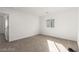 Carpeted bedroom with natural light, features a door into the hallway at 10328 Apefly St, Las Vegas, NV 89141