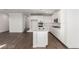 Bright kitchen with stainless appliances, white cabinets and large island flowing to living area at 10328 Apefly St, Las Vegas, NV 89141