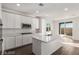 Modern kitchen with stainless appliances, white cabinets, and large island, open to the backyard at 10328 Apefly St, Las Vegas, NV 89141