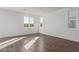 Bright and airy living room with wood-look tile floors and multiple windows at 10328 Apefly St, Las Vegas, NV 89141