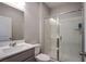 Modern bathroom features a glass-enclosed shower, sleek vanity and neutral finishes at 10590 Dryades Ave, Las Vegas, NV 89166