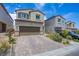 Two-story home with a paver driveway and a two-car garage at 10590 Dryades Ave, Las Vegas, NV 89166