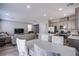 Open-concept living area with modern kitchen, stainless appliances, and cozy seating at 10590 Dryades Ave, Las Vegas, NV 89166