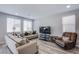 Bright living room features stylish furniture, wood-look floors and large windows at 10590 Dryades Ave, Las Vegas, NV 89166