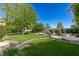 Expansive backyard with lush lawn, stone path, mature trees, and a beautiful pool and spa combination at 10761 Capesthorne Way, Las Vegas, NV 89135
