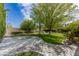 Lush backyard with a basketball court, green lawn, trees, and manicured landscaping at 10761 Capesthorne Way, Las Vegas, NV 89135