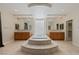 Luxurious bathroom featuring a large soaking tub, dual vanities and tile floors at 10761 Capesthorne Way, Las Vegas, NV 89135
