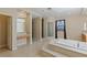 Stunning bathroom with a soaking tub and a glass block window at 10761 Capesthorne Way, Las Vegas, NV 89135