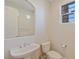 Powder room with a pedestal sink, mirror, and white toilet at 10761 Capesthorne Way, Las Vegas, NV 89135