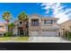 Two-story home with a three-car garage, stone accents, balcony, and palm trees at 10761 Capesthorne Way, Las Vegas, NV 89135