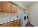 Functional laundry room featuring a utility sink, cabinets, and a washer and dryer at 10761 Capesthorne Way, Las Vegas, NV 89135