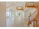 Open living room with stone flooring, high ceilings, staircase, and natural light at 10761 Capesthorne Way, Las Vegas, NV 89135