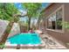 Landscaped backyard with an inground hot tub, BBQ and seating area viewed from the side of the home at 11244 Gammila Dr, Las Vegas, NV 89141