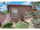 Exterior view of the home featuring a stucco wall, multiple windows, and desert landscaping with trees and shrubs at 11244 Gammila Dr, Las Vegas, NV 89141