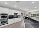 Well-equipped kitchen with stainless steel appliances, granite countertops, white cabinetry, and tile floors throughout at 11244 Gammila Dr, Las Vegas, NV 89141