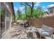 Relaxing patio area with a seating area, outdoor grill, desert landscaping, and shaded by mature trees at 11244 Gammila Dr, Las Vegas, NV 89141