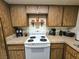 Kitchen area with wood cabinets, tile countertops, and white appliances at 1128 Willow Tree Dr # C, Las Vegas, NV 89128