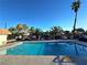 Community pool surrounded by lush palm trees under a bright, clear sky at 1128 Willow Tree Dr # C, Las Vegas, NV 89128