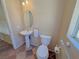Compact half bathroom features a pedestal sink and a tiled floor and is brightly lit at 1564 Silver Knoll Ave, Las Vegas, NV 89123