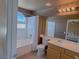 Bright bathroom features a tub/shower combo, white tile, decorative accents, and a vanity at 1564 Silver Knoll Ave, Las Vegas, NV 89123