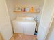 Laundry room with tiled floors, white appliances, and bi-fold doors, making chores a breeze at 1564 Silver Knoll Ave, Las Vegas, NV 89123