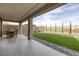 Inviting covered patio extends to a spacious backyard with artificial turf and a charming dining area at 180 Native Stone St, Las Vegas, NV 89138