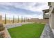 A private backyard with a synthetic lawn, pavers, and well-maintained landscaping at 180 Native Stone St, Las Vegas, NV 89138