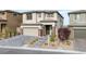Charming two-story home features a brick-accented facade, landscaped yard, and a paved driveway leading to a two-car garage at 180 Native Stone St, Las Vegas, NV 89138