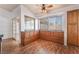 Bright dining area with wood cabinets, three windows, and wood flooring with ceiling fan at 2086 Angel Falls Dr, Henderson, NV 89074