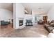 Spacious living room featuring a cozy fireplace, carpet floors, and ample natural light at 2086 Angel Falls Dr, Henderson, NV 89074