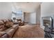Bright living room featuring a cozy fireplace, carpet floors, and a comfortable seating area at 2086 Angel Falls Dr, Henderson, NV 89074