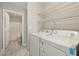 Bright laundry room features a washer, dryer, and overhead wire shelving for storage at 2123 Sleepy Ct, Las Vegas, NV 89106