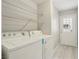 Well-lit laundry area with washer, dryer, wire shelves, and outdoor access at 2123 Sleepy Ct, Las Vegas, NV 89106