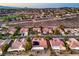 Aerial view showcases community homes with solar panels in a golf course neighborhood nestled in a desert landscape at 2319 Hardin Ridge Dr, Henderson, NV 89052
